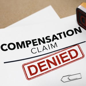 A red stamp with the word 'DENIED' is placed over a document requesting compensation claim denied. - Leep Tescher Helfman and Zanze