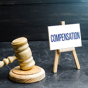 Judge gavel and sign reading compensation representing Workers' Comp claims - Leep Tescher Helfman and Zanze
