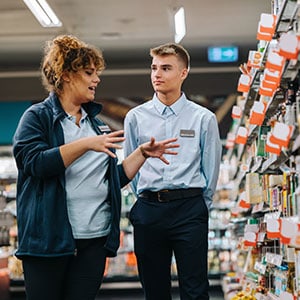 A man and woman in a supermarket aisle discussing Safety Tips For Retail Workers - Leep Tescher Helfman and Zanze