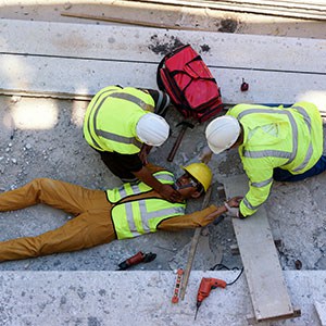Two workers help injured colleague at work site, urgent rescue in progress - Leep Tescher Helfman and Zanze