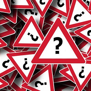 Red and white signs with question marks in a pile, representing workplace safety errors - Leep Tescher Helfman and Zanze
