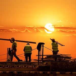 Workers on a construction site, outlined by the setting sun - Leep Tescher Helfman and Zanze