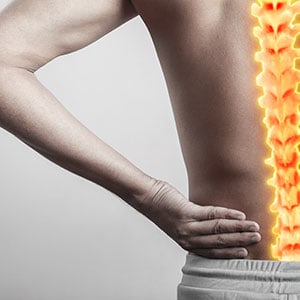 A man with back pain, highlighted spine - Leep Tescher Helfman and Zanze