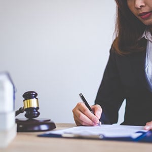 A lawyer is writing on a piece of paper about a workplace injury claim - Leep Tescher Helfman and Zanze