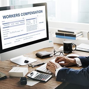 Person is using computer, Workers’ Compensation Claim form on screen. - Leep Tescher Helfman and Zanze