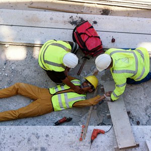 Construction workers lying on the ground, representing workplace injuries - Leep Tescher Helfman and Zanze
