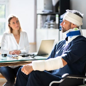 A man with a Workers’ Compensation Claims cast on his arm is seated. - Leep Tescher Helfman and Zanze