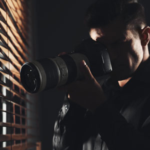 A person filming a video in a workplace setting to use as evidence in an injury claim, positioned near a window.